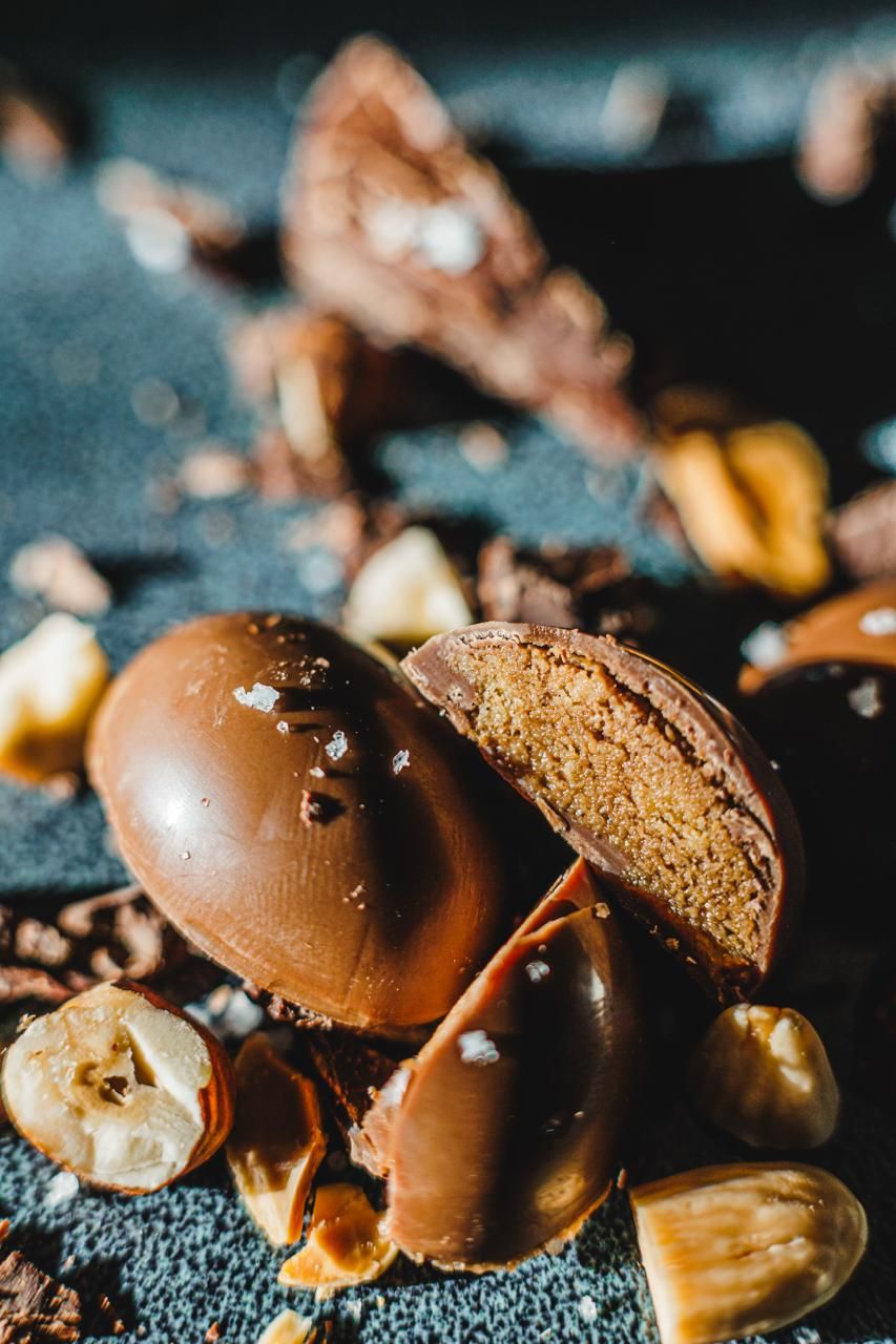 Une pralinette coupée en deux, qui révèle son praliné sous la coque de chocolat au lait